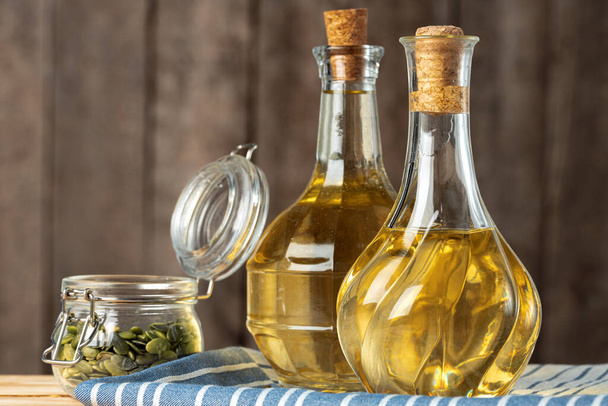 Olive oil bottle on wooden table, close up. - Fotoğraf, Görsel