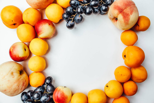 Fruit peaches, apricots and grapes on white background - Valokuva, kuva