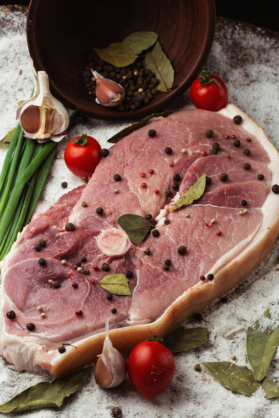 Slices of raw pork knuckle on wooden background. Raw pork meat isolated with vegetables. Advertising for meat shop and farm. Various kinds of meat and ready to cook concept. Top view. - Photo, image