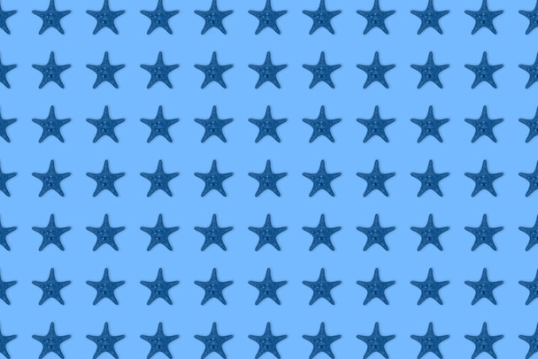 Сушёная тонировка синей морской звезды на синем фоне. Вид сверху, минимально плоский стиль. Баннер или плакат
. - Фото, изображение