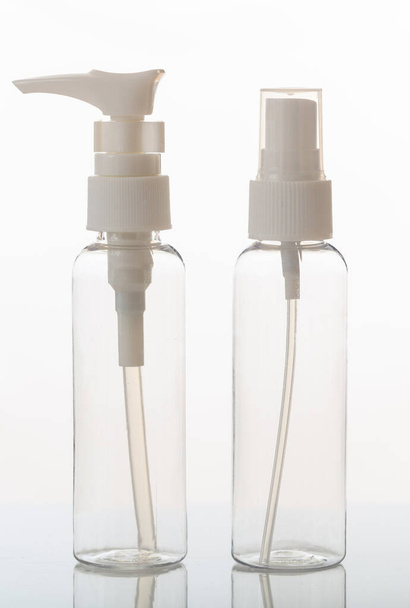Leere transparente Kosmetikflaschen isoliert auf weißem Hintergrund. Klarglas- oder Kunststoffflaschen mit Spender oder Deckel. Vertikales Foto. - Foto, Bild