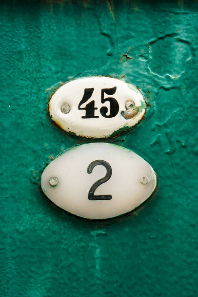 Número quarenta e cinco e dois ligados a um velho portão verde enferrujado
. - Foto, Imagem