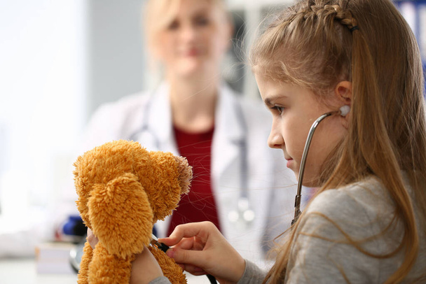 Close up of serious girl that playing with stethoscope - Photo, Image