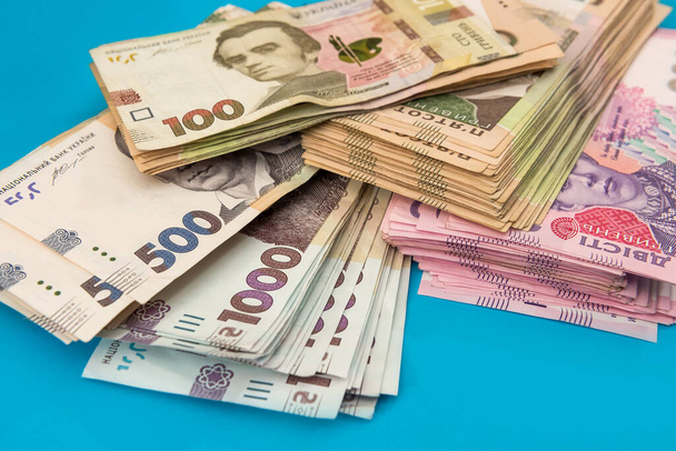 Grivna ucraniana dinero nuevos billetes 1000 y 500 aislados en azul. Una pila de dinero. UAH - Foto, Imagen