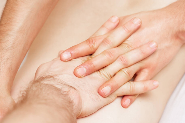 Жінка отримує масаж спини руками чоловіка-терапевта
. - Фото, зображення