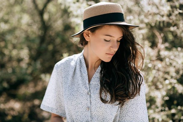 Portrait of a beautiful young brunette woman in a hat in the park - Foto, Imagem