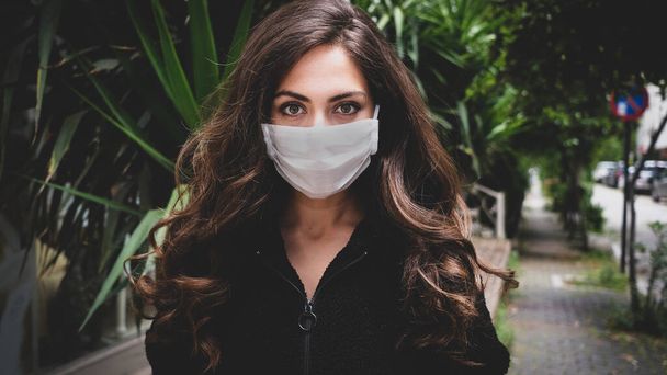 Fiatal nő orvosi maszkot visel, hogy megvédje a koronavírust az utcán - Fotó, kép