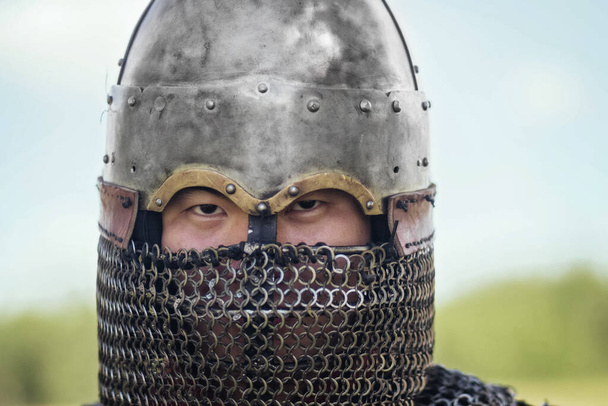 Close up face of asian warrior in eastern medieval helmet. A stern look. - Foto, Imagem