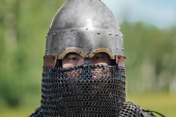 Close up face of asian warrior in eastern medieval helmet. A stern look. - Fotografie, Obrázek