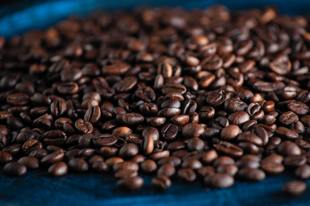 pražená aromatická kávová zrna detailně posypaná na stole - Fotografie, Obrázek