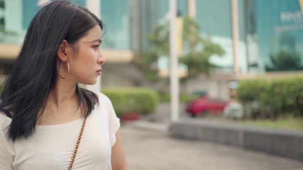 Beautiful depressed Asian female side view, model looking away, short black hair young woman worried and sad close up front portrait, standing alone in park, out door natural light, SLOW MOTION - Footage, Video