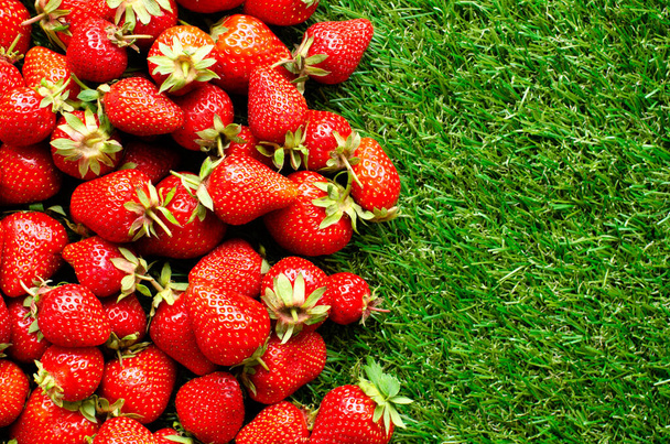 red fresh strawberries on green grass, close view - Photo, Image