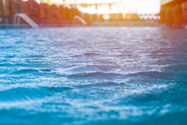 Lagoa azul água fria onda da piscina ondulação closeup com luz ensolarada sensação de resfriamento no dia de verão
. - Foto, Imagem