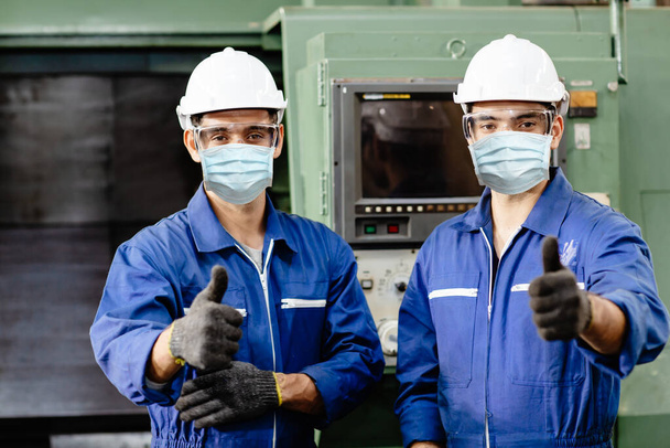 Coronavirus 'u (Covid-19) veya fabrikadaki hava kirliliğini önlemek için fabrikada çalışırken yüz maskesi ya da tek kullanımlık yüz maskesi takan işçiler. - Fotoğraf, Görsel