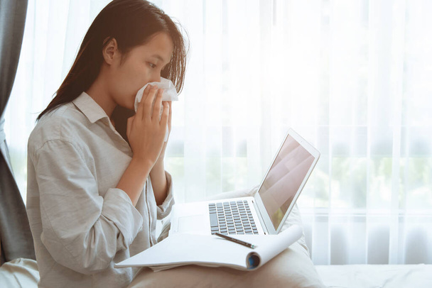 Mädchen Teenager wischen Nase während Online-Homeschooling mit Grippe-Erkrankung Coronavirus (Covid-19) infiziert, zu Hause bleiben und mit Laptop-Computer Selbstpflege während Lockdown der Stadt arbeiten. - Foto, Bild