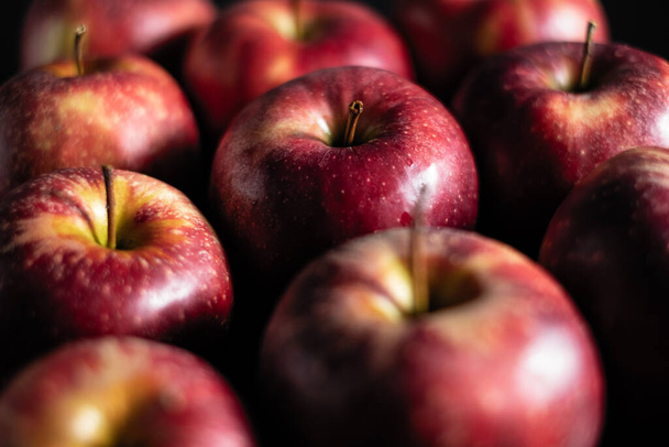 manzanas rojas fragantes se encuentran en una fila sobre un fondo oscuro
 - Foto, Imagen
