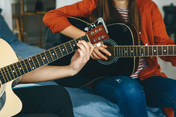 Megtanulni gitározni. A tanár elmagyarázza a diáknak a gitározás alapjait. Egyéni otthoni oktatás vagy iskolán kívüli órák. - Fotó, kép