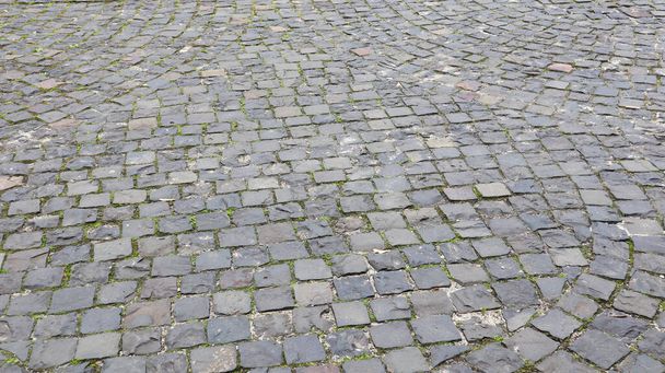 Side view of the cobblestones of the street. Detailed photo of the road surface. Traditional artwork on roads and sidewalks in the old part of the city - Photo, Image