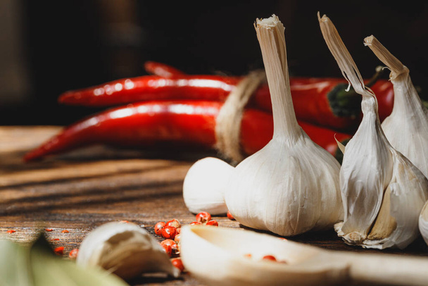 Garlic and chili pepper on dark wooden table - Foto, Imagen