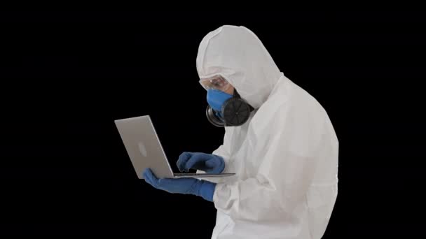 Doctor in protective suit working on laptop and having good results, Alpha Channel - 映像、動画