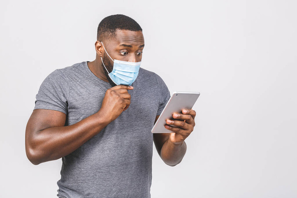 Medical news! African american man in medical sterile mask holding digital tablet isolated on white background.  - Photo, Image