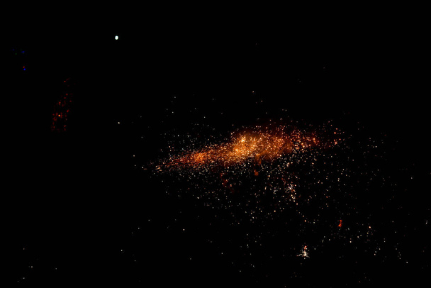 pomarańczowe żywe cząstki ognia na odizolowanym czarnym tle - Zdjęcie, obraz