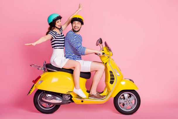 Profile side view portrait of his he her she nice attractive lovely carefree childish playful cheerful cheery glad couple riding moped having fun fooling isolated on pink pastel color background - Foto, imagen