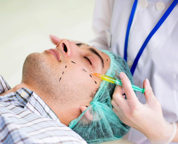 Πλαστικός χειρουργός ετοιμάζεται για χειρουργική επέμβαση στο πρόσωπο του ανθρώπου - Φωτογραφία, εικόνα