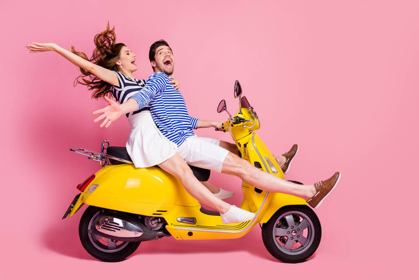 Profile side view portrait of his he her she nice attractive cheerful cheery crazy carefree couple riding moped spending free time having fun fooling isolated on pink pastel color background - Foto, immagini