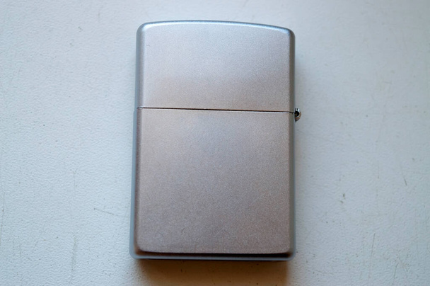 Zippo lighter closed, lying on a white base - 写真・画像
