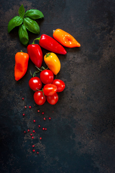 Close-up photo of fresh vegetables and spices. Top view on dark concrete table background - Zdjęcie, obraz