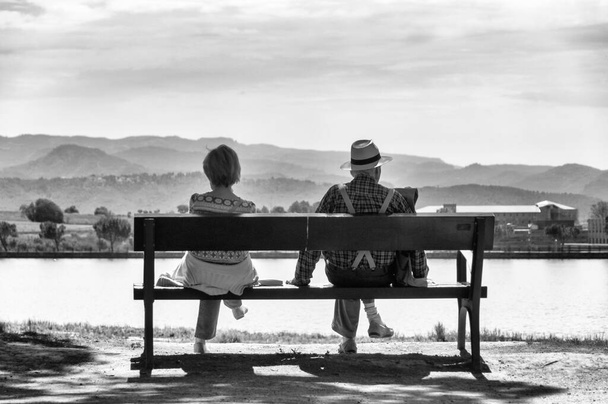 静かな朝に美しい湖を見ている老夫婦. - 写真・画像