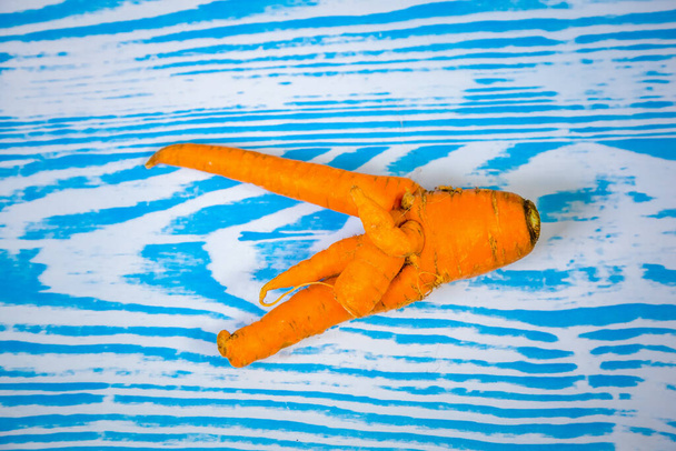 Свежая, уродливая морковь, согнутая и скрученная. Забавная морковка в форме человеческих пальцев. Смешная серия морковок
. - Фото, изображение