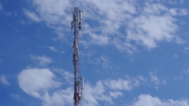 Een ingenieur van een mobiel bedrijf bedient een mobiel zendstation. 5g cellulaire dekking. Werk op grote hoogte. - Video