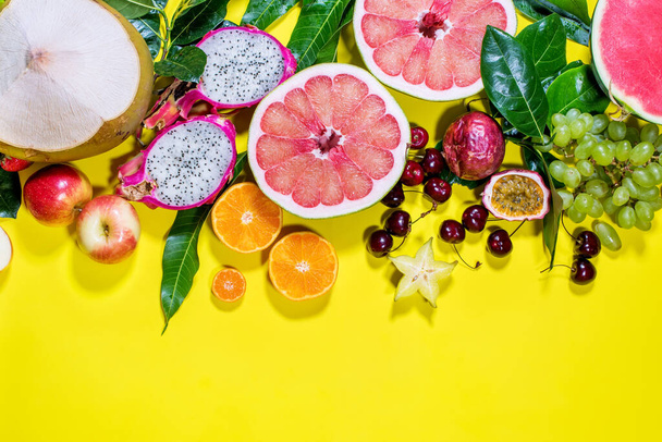 Different exotic tropical fruits berryes in line on yellow bakground. Raw eating diet concept. Super natural food background. High resolution. Top view - Foto, afbeelding