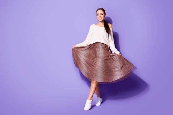 Full size photo of nice lovely girl enjoy rest relax weekend hold her skirt feel fun wear stylish outfit brown isolated over violet color background - 写真・画像