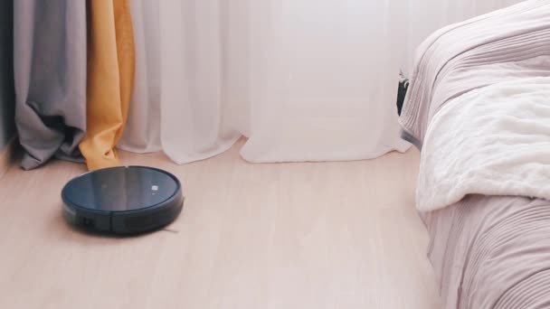 Черный робот-пылесос очищает комнату
 - Кадры, видео