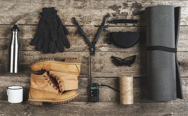 Top view of assorted hiking equipment tools on grunge wooden background - Foto, immagini