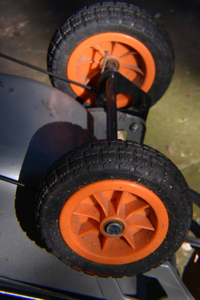 Two orange and black wheelbarrow wheels. - Photo, Image