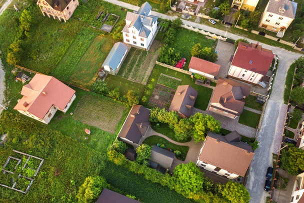 Kisváros vagy falu légi tájképe lakóházak és zöld fák soraival. - Fotó, kép