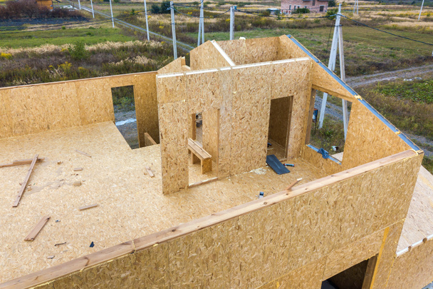 Строительство нового и современного модульного дома. Стены из композитных деревянных потягивающих панелей с изоляцией из пенопласта внутри. Построение новой концепции энергосберегающего дома. - Фото, изображение