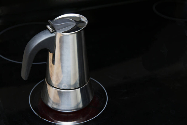 крупним планом кавоварка з нержавіючої сталі на плиті на кухні
. - Фото, зображення