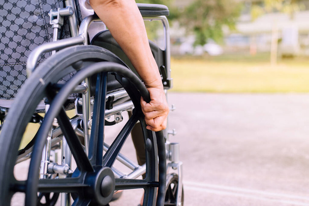 Disabled woman sitting on wheelchair at outdoor,Recovery and healthcare concept - Photo, image