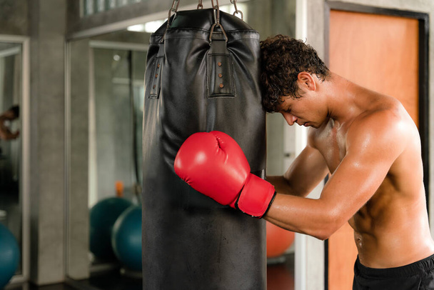 caucasian male boxer training boxing by punching sand bag in gym and fitness club - Fotoğraf, Görsel