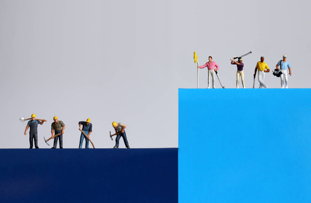 Miniature people. A concept on the gap between the rich and the poor. - Photo, Image