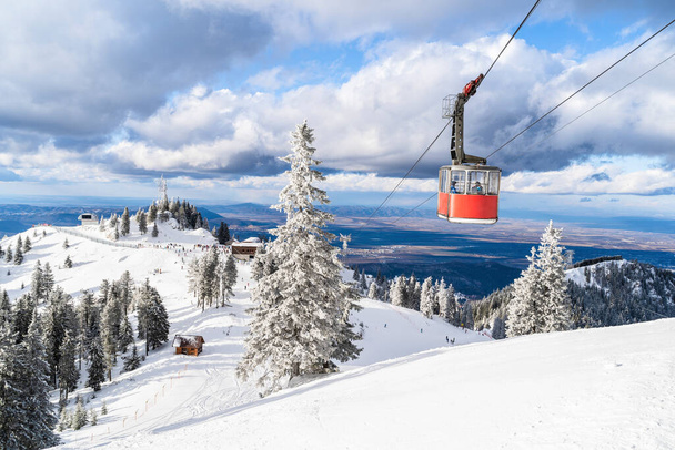 Landscape from top of Postavaru mountain with ski slopes and cable car transporting in Poiana Brasov, Romania - Photo, Image
