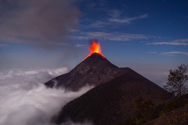 Erupção vulcânica sobre as nuvens no vulcão irmãs Acatenango, Volcan del Fuego explosão sobre as nuvens à noite
. - Foto, Imagem