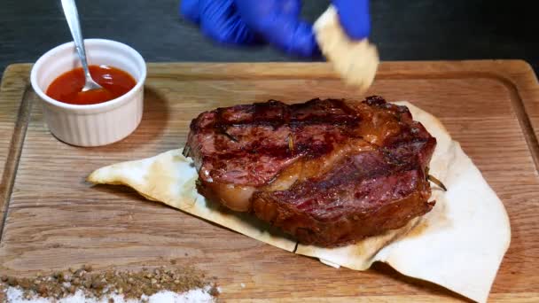 Heerlijke biefstuk. Rundvlees biefstuk op houten bord. Middelgeroosterde biefstuk op een houten plank met saus.  - Video