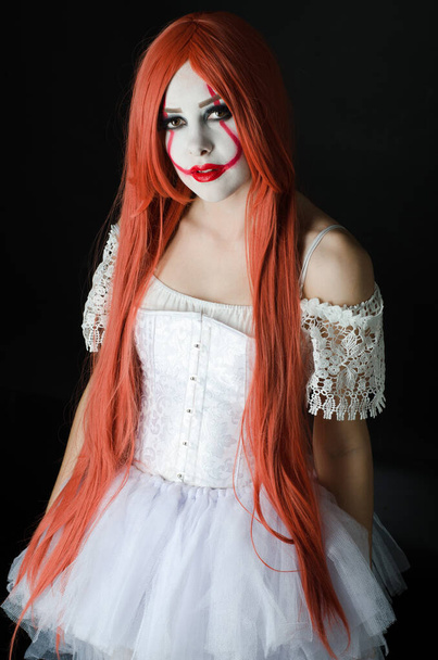 dívka v kostýmu klauna s děsivým make-up na černém pozadí - Fotografie, Obrázek