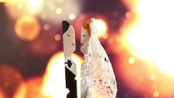 新郎と花嫁のキスとして描かれた服ピン手は、彼らの結婚式の特別な日にボケ焦点を当てた光の背景にキス - 映像、動画